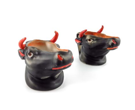 A pair of Royal Bayreuth porcelain black Cow creamers, modelled in relief, with red horns and eyes, 10cm high (2)