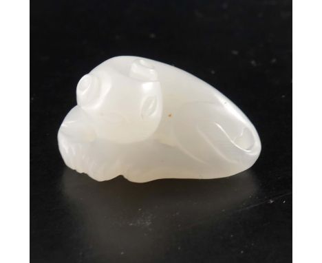 A Chinese carved white jade pendant, modelled as a coiled lion, mutton fat colour, 3cm long