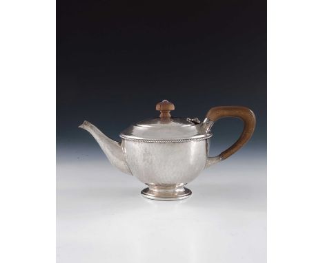 A E Jones, an Arts and Crafts silver teapot, Birmingham 1922, planished and footed hemispherical form with applied ropetwist 