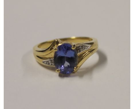 A 9ct yellow gold ladies' dress ring, central blue oval tanzanite with tiny diamond chip stones to shoulders, size N, approx 