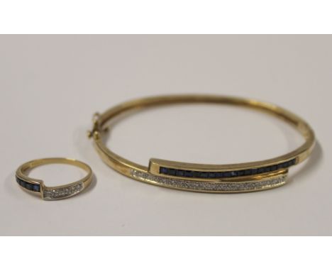 A 9ct yellow gold bangle with hinge fastening, set with dark blue stones and white diamonds and a matching 9ct gold ring, com