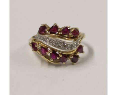 A 14ct yellow gold ladies' dress ring set with rubies and central band of small diamond chips, size S, approx 6g.