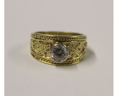 A 14ct gold ladies' dress ring with one collet-set white stone to the centre, heavily engraved to either side of the band, si