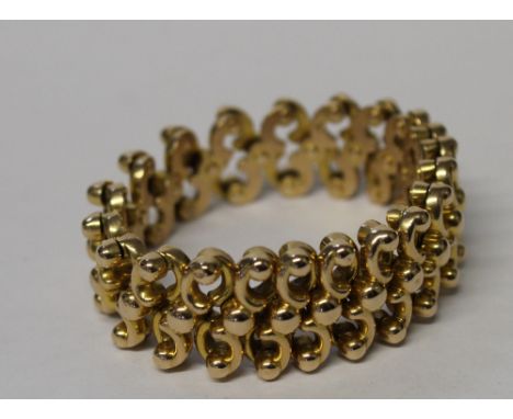 A 15ct yellow gold expanding link bracelet, jointed for C-scrolls with small bead top rivet joining links and a larger bead t