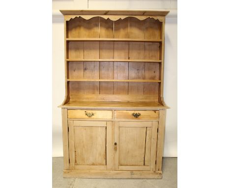 A Victorian pine dresser with boarded three-shelf plate rack above twin short drawers and cupboard doors, approx 210 x 130cm.