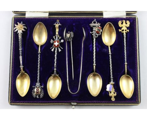 A cased set of six Swiss silver gilt cantons marked 800, a pair of EPNS sugar tongs and a Swiss stick pin (3).