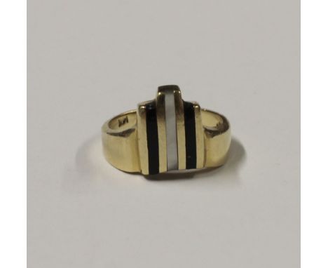 An Art Deco style yellow metal ring with mother of pearl and black enamel detail, stamped 14K to band interior, size O, appro