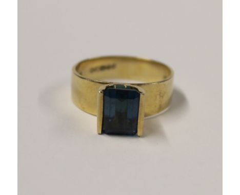 A 9ct yellow gold ladies' dress ring, raised setting with emerald-cut blue stone (tests as aquamarine), size Q, approx 5.5g.