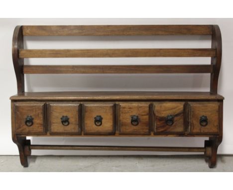 A reproduction hardwood hanging shelf, with plate rack above six small drawers, width 75cm.