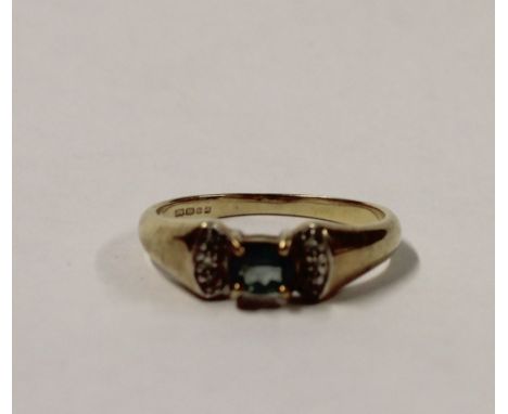 A 9ct yellow gold ladies' dress ring with green topaz to the centre and diamond chips to the shoulder, size N, approx 2.3g.