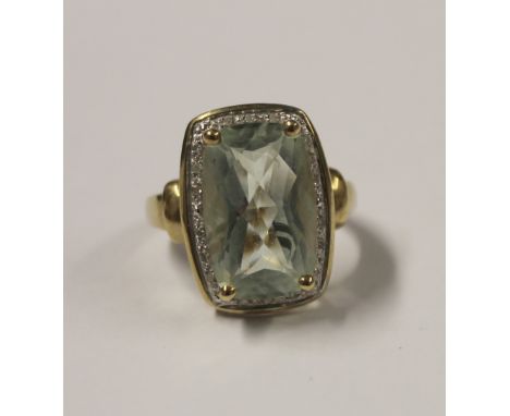 A 9ct yellow gold ladies' dress ring with pale green tourmaline and small diamond surround, size L, approx 5.3g.