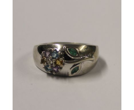 A 9ct white gold ladies' dress ring with raised floral decoration, varicoloured topaz stones and enamelled leaf, size Q, appr