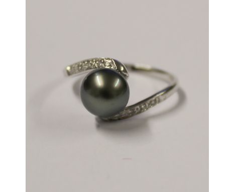 A 14ct white gold ladies' dress ring set on a twist with a single grey pearl and small diamond chips to the shoulders, size S