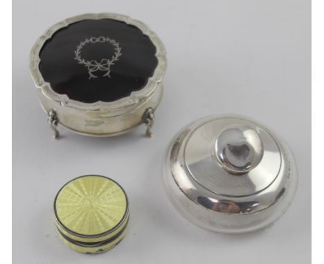 A George V hallmarked silver and tortoiseshell circular jewellery box with silver pique work to the tortoiseshell, on four ho