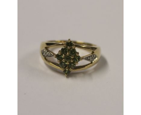 A 9ct yellow gold ladies' dress ring, marquise setting with small green stones and diamond chips to the split shoulder, size 