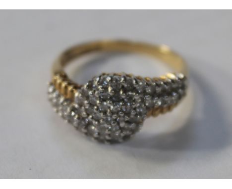 An 18ct yellow gold ladies' dress ring, pavé-set with small diamonds on a twist, size Q, approx 5.2g.