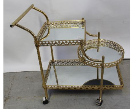 An ornate gilded and mirrored trolley, square shelf to the top above a circular tray and a lower rectangular tray and an orna