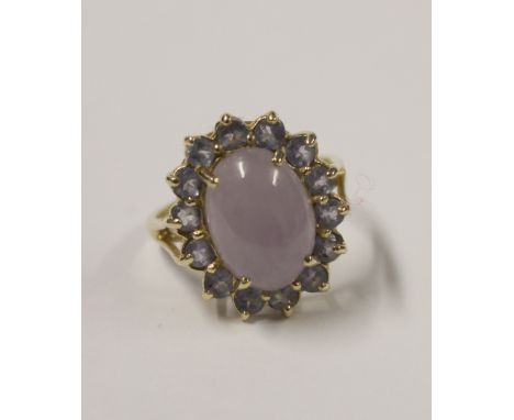 A 14ct yellow gold ladies' dress ring, cabochon lilac jade central stone with pale amethyst-coloured stone surround, size R, 