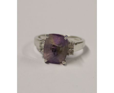 A 9ct white gold ladies' dress ring with facet-cut multicolour amethyst stone, two small white stones to either shoulder, siz