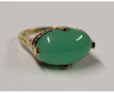 An 18ct gold ladies' dress ring, cabochon-set green jade stone with small ruby surround, size R, approx 7.4g.