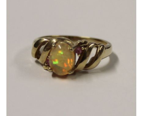 A 9ct yellow gold ladies' dress ring with cabochon jelly opal and small pink stone to either side, size N, approx 3.2g.