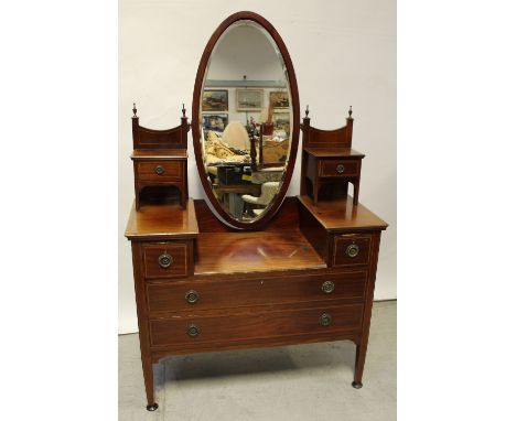 A late 19th/early 20th century mahogany bow-front twin mirror door wardrobe, bow-front twin-door cupboard to the centre, abov