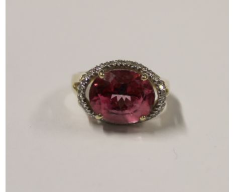 A 9ct yellow gold ladies' dress ring with oval faceted pink topaz and small diamond surround, size L, approx 4.2g.