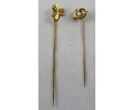 An 18ct yellow gold stick pin, lovers' knot with central pearl and a 9ct gold shamrock stick pin (2).