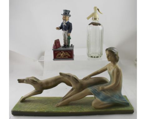 A c1930s Art Deco plaster figure of a young woman and dogs on a stylised grassy plinth, length 54cm, a vintage Schweppes soda