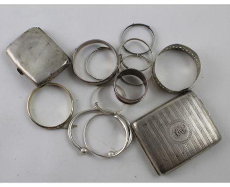 A group of variously hallmarked silver items to include two cigarette cases, snap bangles, napkin ring, also six adjustable b