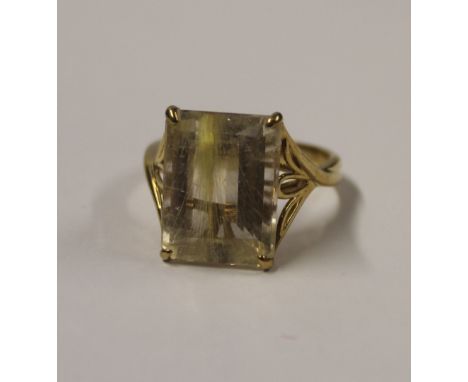 A 9ct yellow gold ladies' dress ring with large emerald-cut rutilated quartz with filigree shoulders, size S, approx 6.1g.