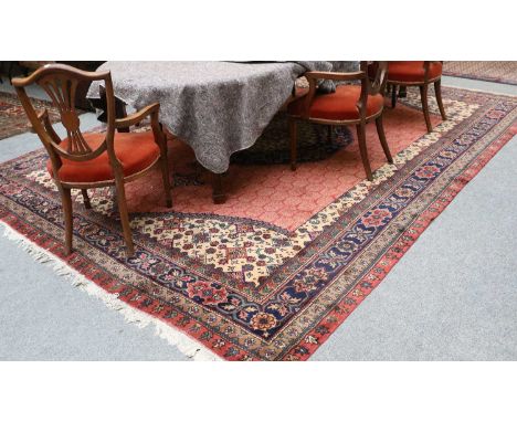 Isparta Carpet, the terracotta field centred by a large indigo and ivory medallion framed by camel spandrels and indigo borde
