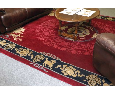 Large Chinese Carpet, the deep cherry field centred by a roundel surrounded by scrolling vines, enclosed by indigo borders of