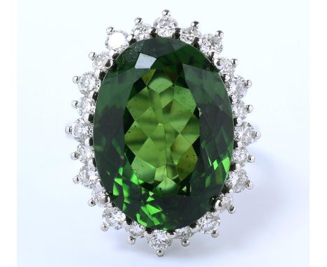18 kt. Witgouden ring centraal bezet met een grote groene toermalijn, van ca. 14.00 ct., in een entourage van  briljant gesle