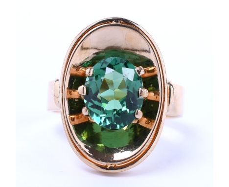 Beneden wettelijk gehalte gouden ring, jaren 70, bezet met een helder groene ovale toermalijn van ca. 2.25 ct. bruto 4,25 gr.