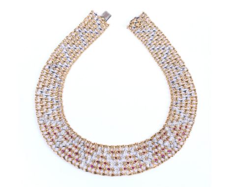 18 kt. Gouden kraagcollier, 'à la Egypte', in wit,- en geelgoud. Bezet met robijn (totaal ca. 1.50 ct.) en briljant geslepen 