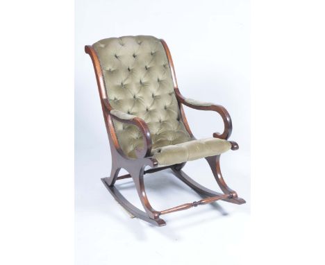 A Victorian style mahogany framed rocking chairWith a green velour padded button back above scroll  terminal arms with outswe