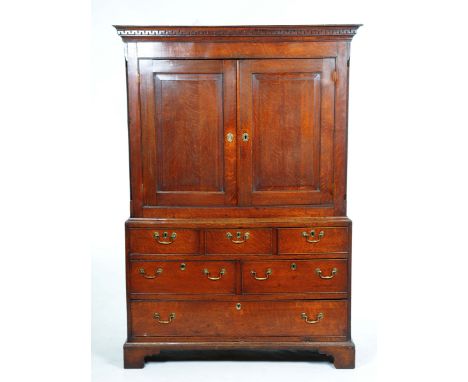 An impressive George III oak linen pressWith a cavetto Greek key pattern cornice above a pair of panelled cupboard doors encl