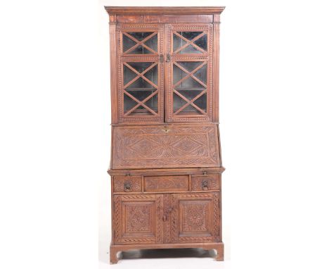 An 18th Century and later carved oak bureau bookcaseWith a moulded cornice above a pair of carved astragal glazed doors, flan