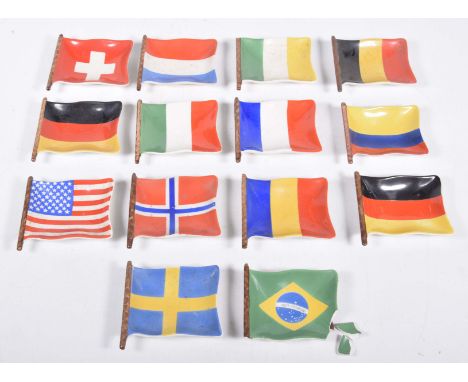 Fourteen Gilman & Co national flags of the World ceramic dishes, each dish in the form of a flag with flag staff. (one a/f)