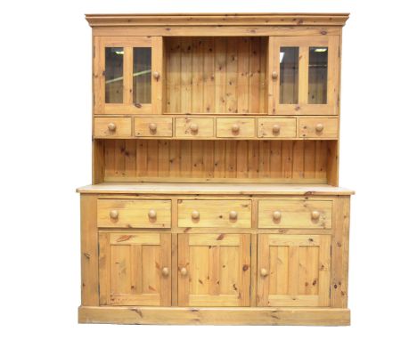 A pine kitchen dresser, 20th CenturyThe high back with a moulded cornice above a central open shelf, flanked by two glazed cu