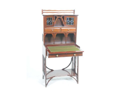 An attractive early 20th Century mahogany Arts & Crafts Bonheur du JourThe top with two wavy rails above a central recess fla