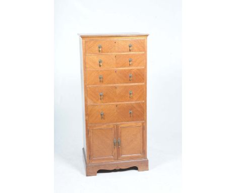 An early 20th Century walnut chest of drawers by Shapland & PetterThe rectangular moulded top above five drawers and two cupb