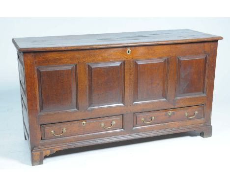An exceptional George III oak mule chestThe rectangular moulded three plank top enclosing a fitted candle box above four pane