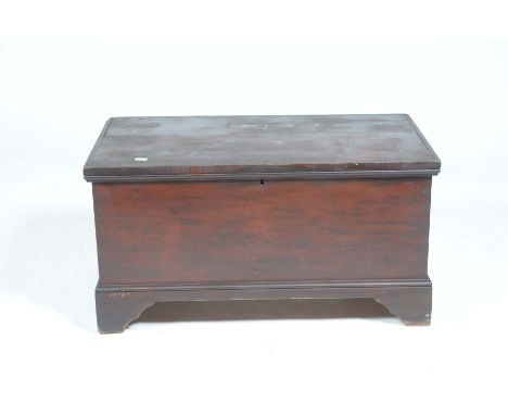 A Victorian stained pine blanket chest The hinged top enclosing a fitted candle box, with side iron swing handles raised on b