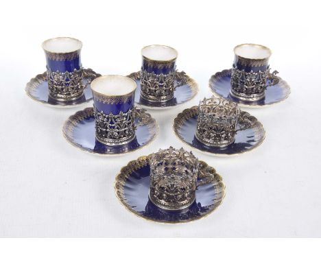 A Royal Worcester and silver matched coffee set AF, comprising six saucers, four cans each within hallmarked silver holders a