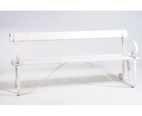 An early 20th Century wrought iron and hardwood garden benchWith a single rail back above a slatted seat raised on scroll end