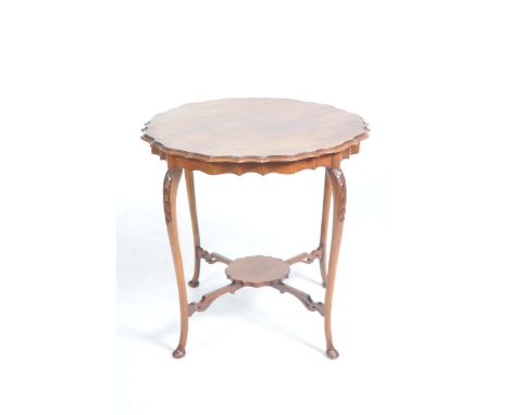 A late Victorian walnut occasional tableThe circular top with a shaped moulded border, raised upon four leaf carved curviline