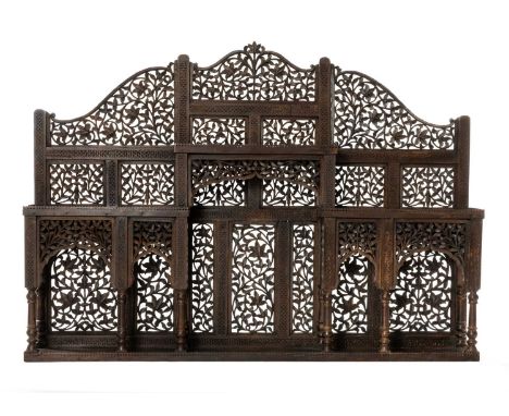 INDIAN CARVED HARDWOOD SHELF, probably Lahore, with mihrab shaped alcoves, turned columns and shelves, pierced foliate decora