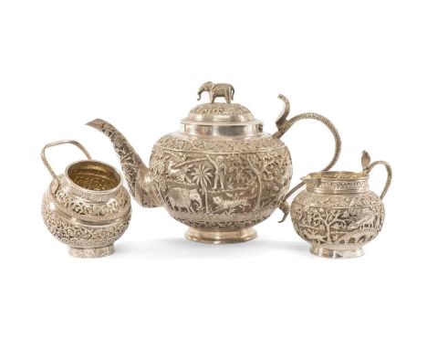 INDIAN WHITE METAL TEA SERVICE, comprising teapot, 24cms (l), sugar bowl and milk jug, all with cobra handles, decorated with